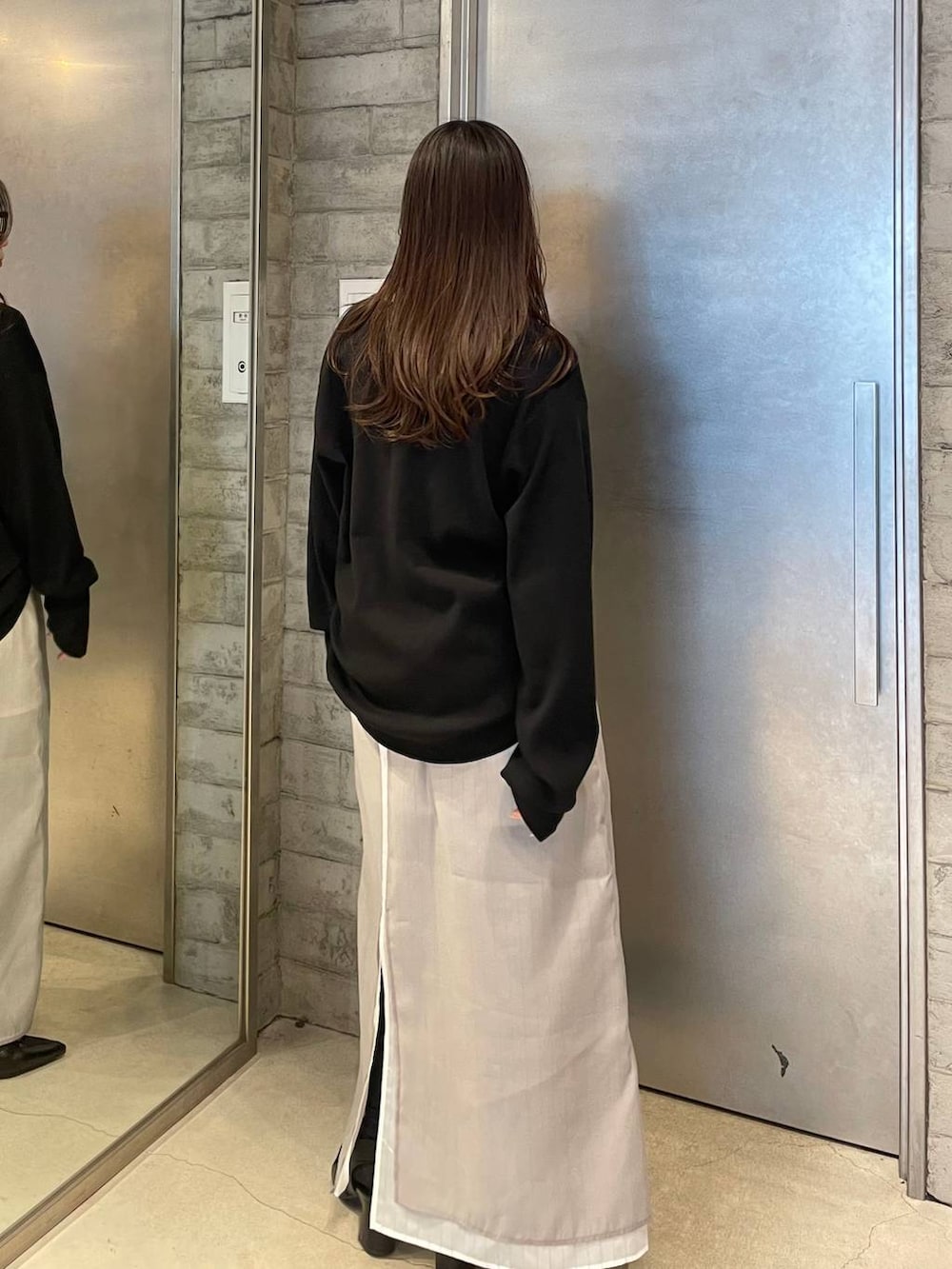 ブラック系のサンダル、ベージュ系のスカート、ブラック系のTシャツ/カットソーを着用したレディースの春コーディネートの3枚目の写真