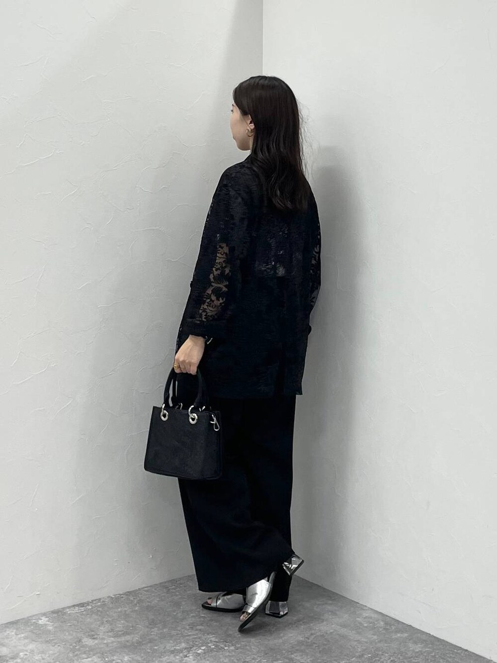 シルバー系のサンダル、ブラック系のショルダーバッグ、ブラック系のTシャツ/カットソーを着用したレディースの夏コーディネートの3枚目の写真