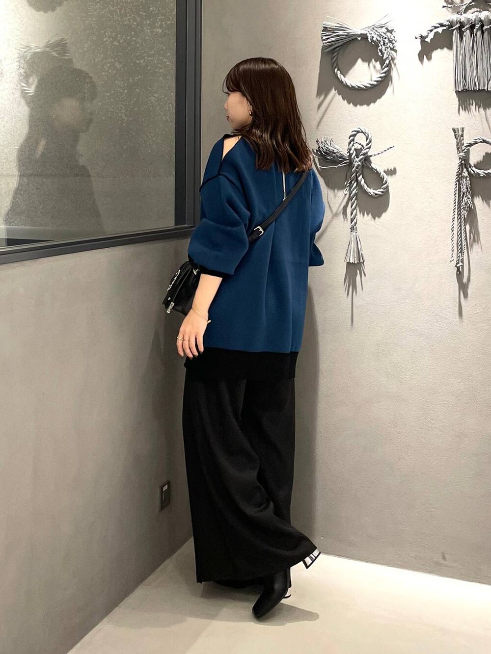 ブラック系のネクタイ、ブラック系のブーツ、ブラック系のショルダーバッグを着用したレディースの秋コーディネートの2枚目の写真