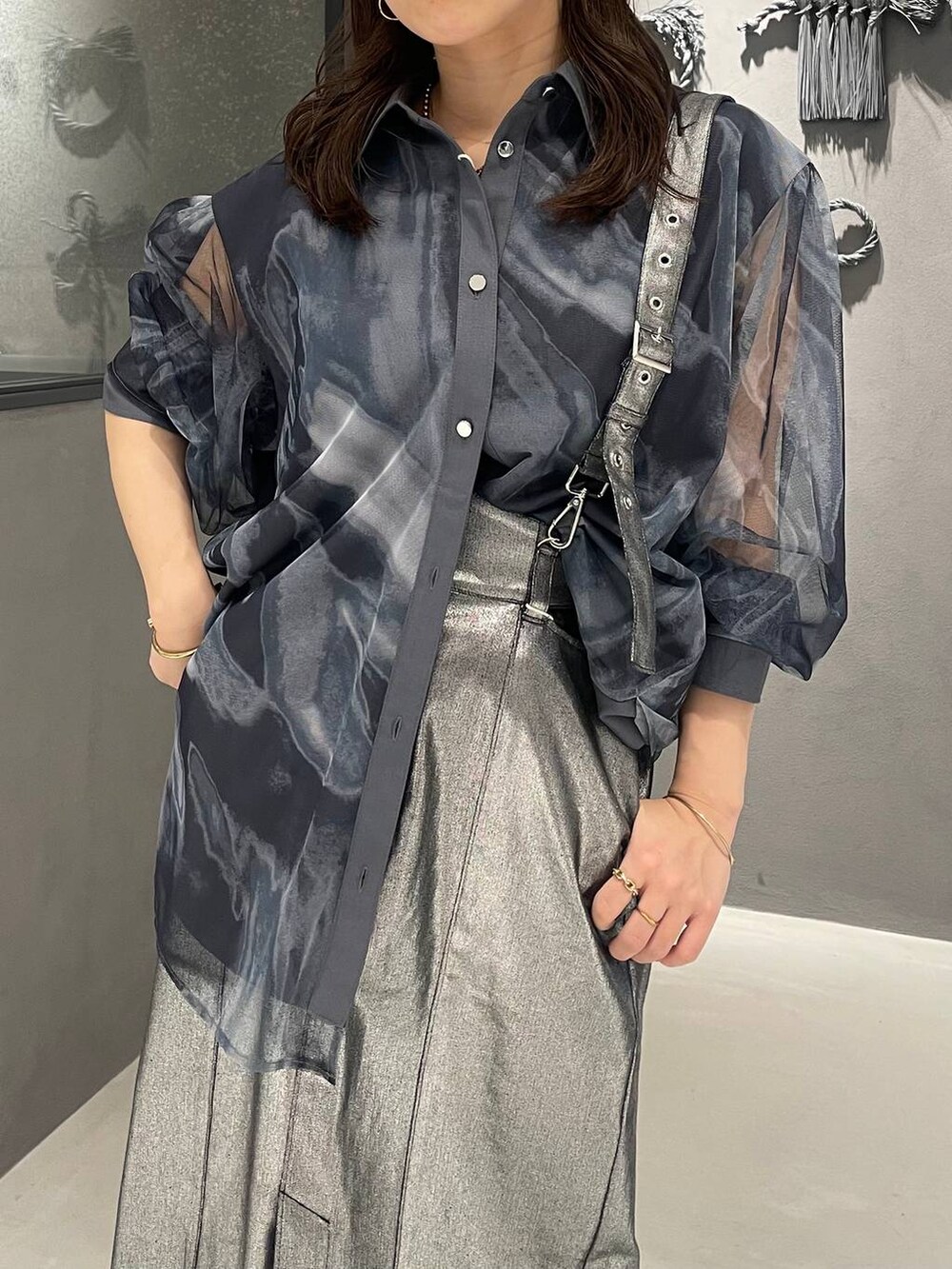 ブラック系のサンダル、シルバー系のスカートを着用したレディースの春コーディネートの4枚目の写真