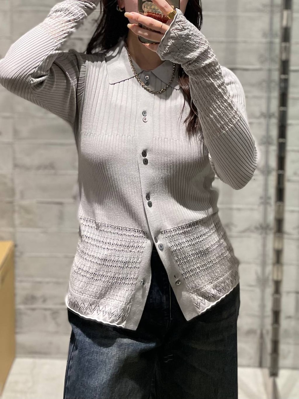 ブルー系のデニムパンツ、ブラック系のブーツ、グレー系のカーディガン/ボレロを着用したレディースの冬コーディネートの3枚目の写真