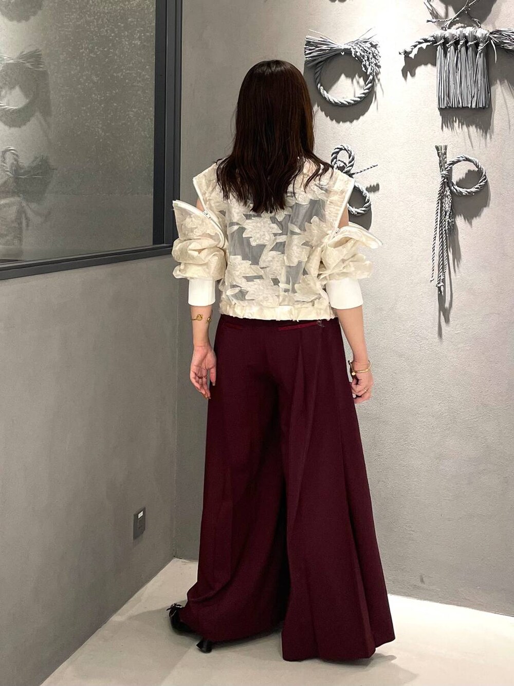 ブラック系のタンクトップ、ブラック系のパンプス、ホワイト系のブルゾンを着用したレディースの夏コーディネートの2枚目の写真