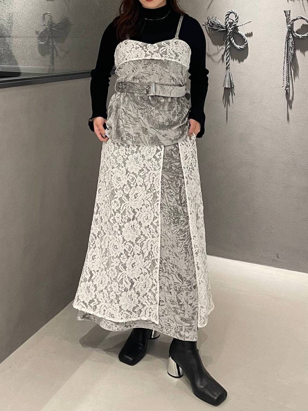 ブラック系のニット/セーター、ブラック系のブーツ、グレー系のベストを着用したレディースの秋コーディネートの3枚目の写真