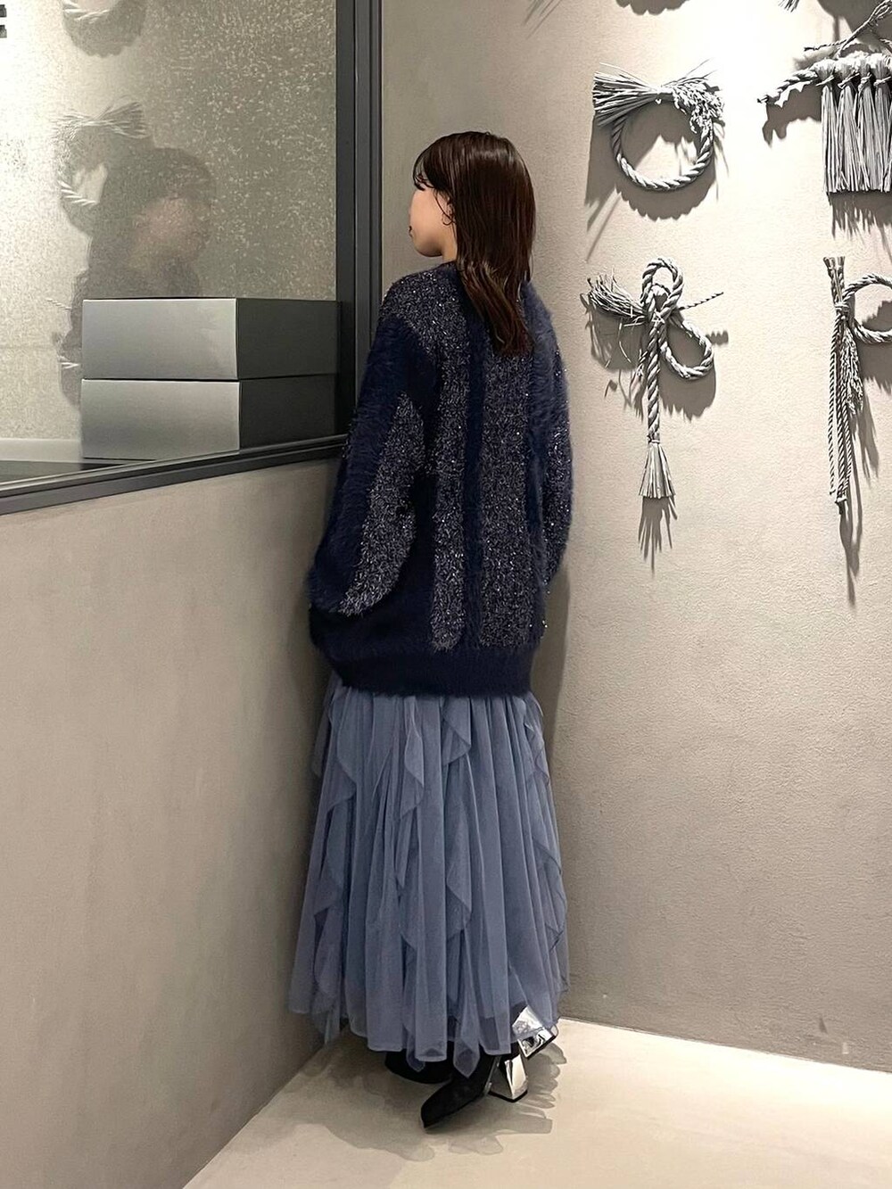ブラック系のブーツ、ブルー系のカーディガン/ボレロ、グリーン系のTシャツ/カットソーを着用したレディースの冬コーディネートの2枚目の写真