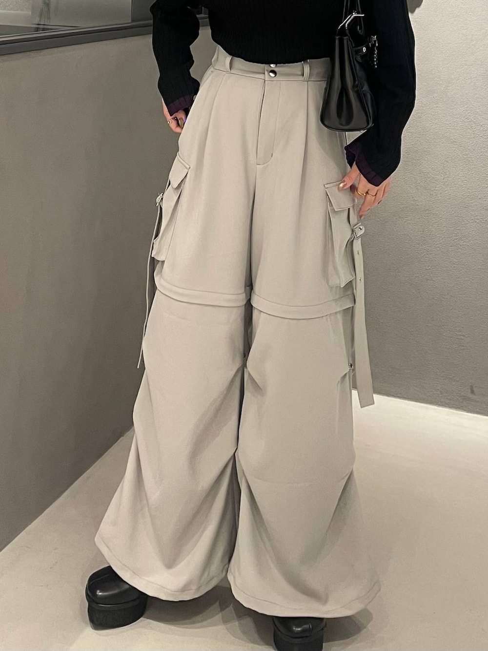 ホワイト系のカーゴパンツ、ブラック系のブーツ、ブラック系のボストンバッグを着用したレディースの冬コーディネートの5枚目の写真