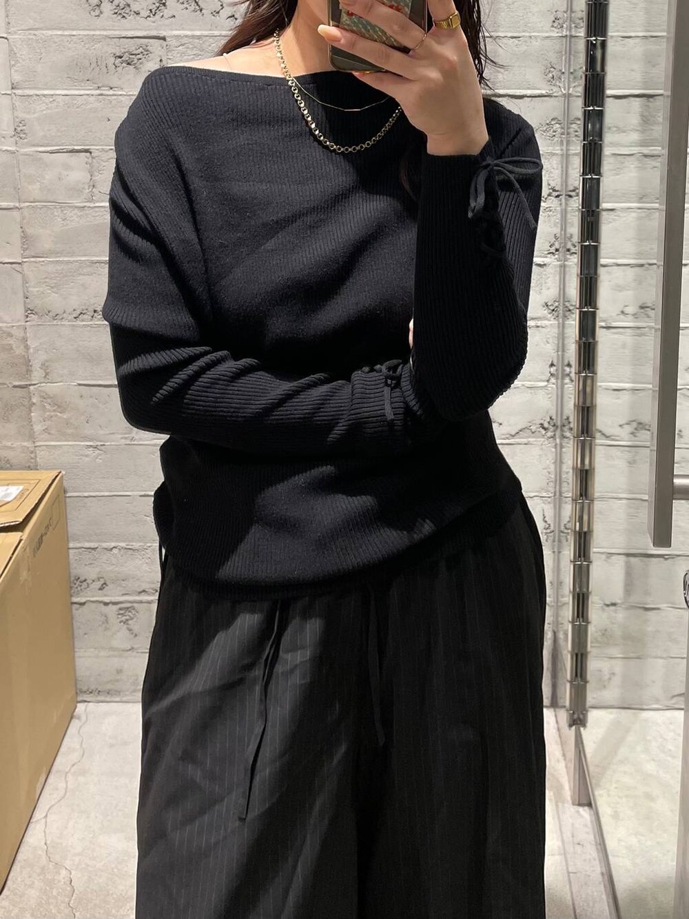 ブラック系のニット/セーターを着用したレディースの冬コーディネートの2枚目の写真