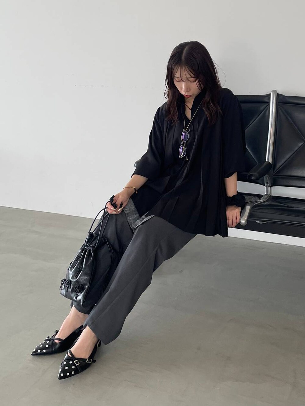 ブラック系のパンプス、ブラック系のショルダーバッグ、ブラック系のシャツ/ブラウスを着用したレディースの夏コーディネートの3枚目の写真