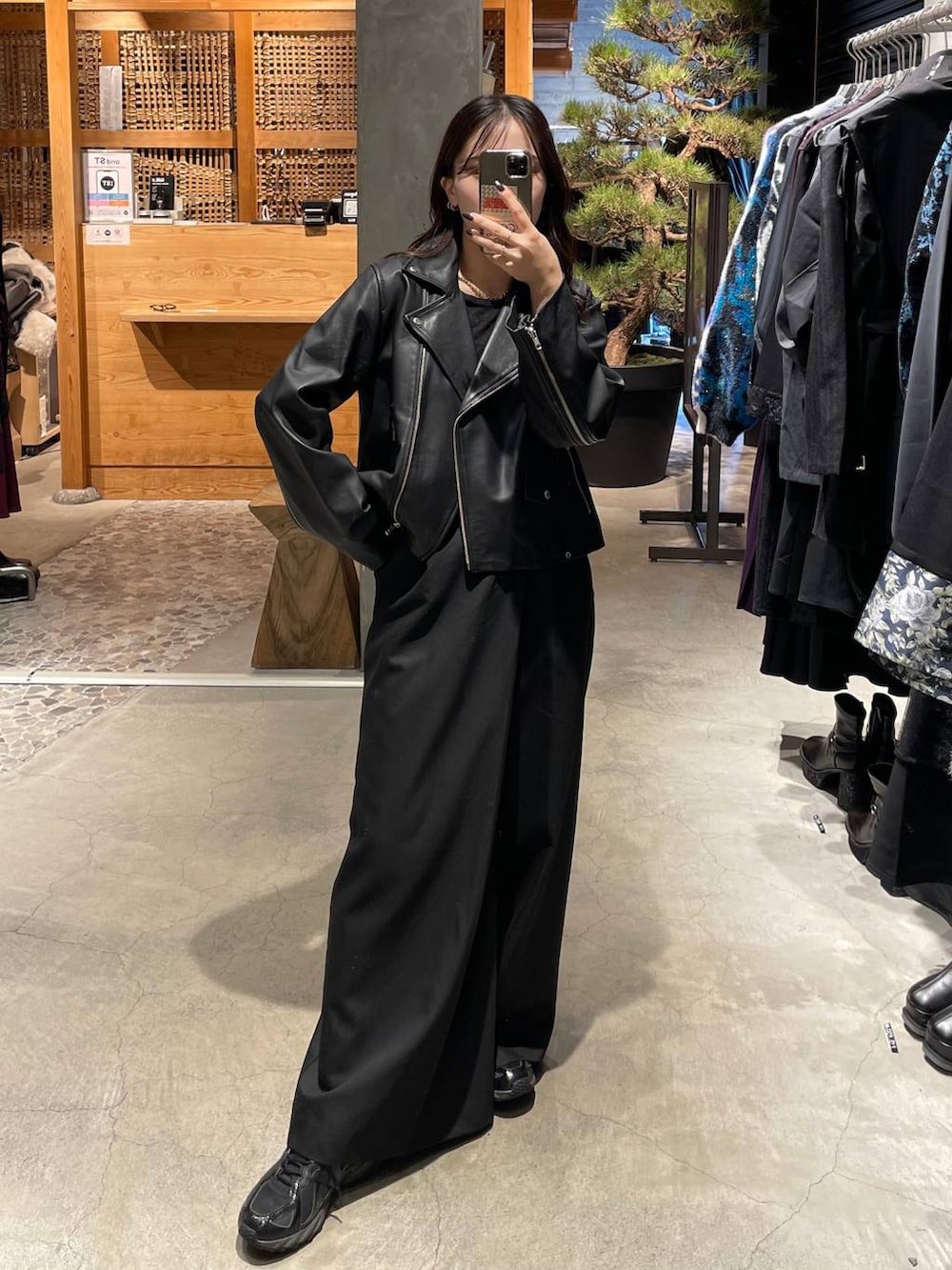 ブラック系のライダースジャケット、ブラック系のスラックスを着用したレディースの秋コーディネートの2枚目の写真