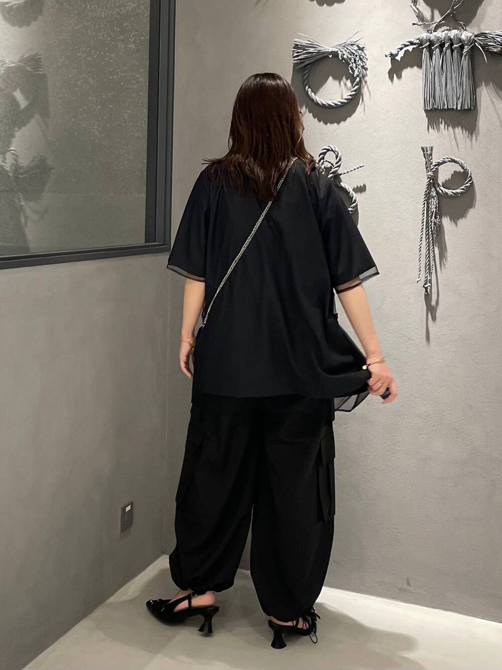 ブラック系のショルダーバッグ、ブラック系のパンプス、ブラック系のカーゴパンツを着用したレディースの夏コーディネートの2枚目の写真