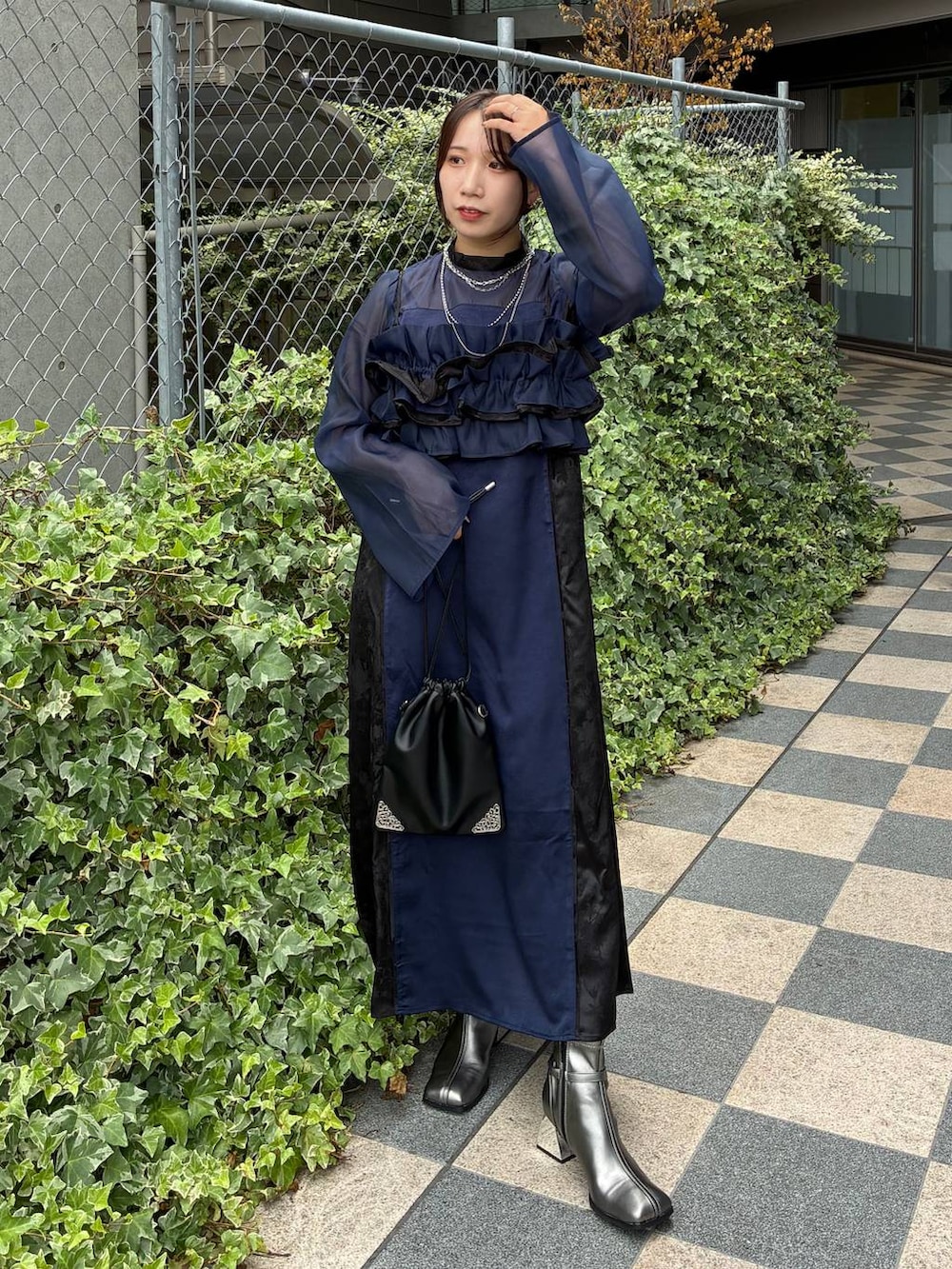 ブルー系のワンピース、ブラック系のトートバッグ、シルバー系のネックレスを着用したレディースの夏コーディネートの2枚目の写真