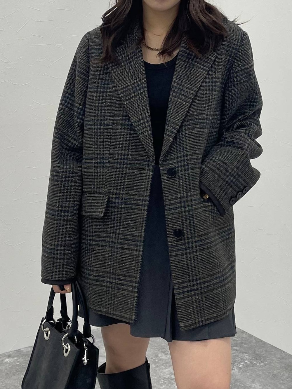 ブラック系のTシャツ/カットソー、ブラック系のショルダーバッグ、ブラック系のブーツを着用したレディースの秋コーディネートの6枚目の写真