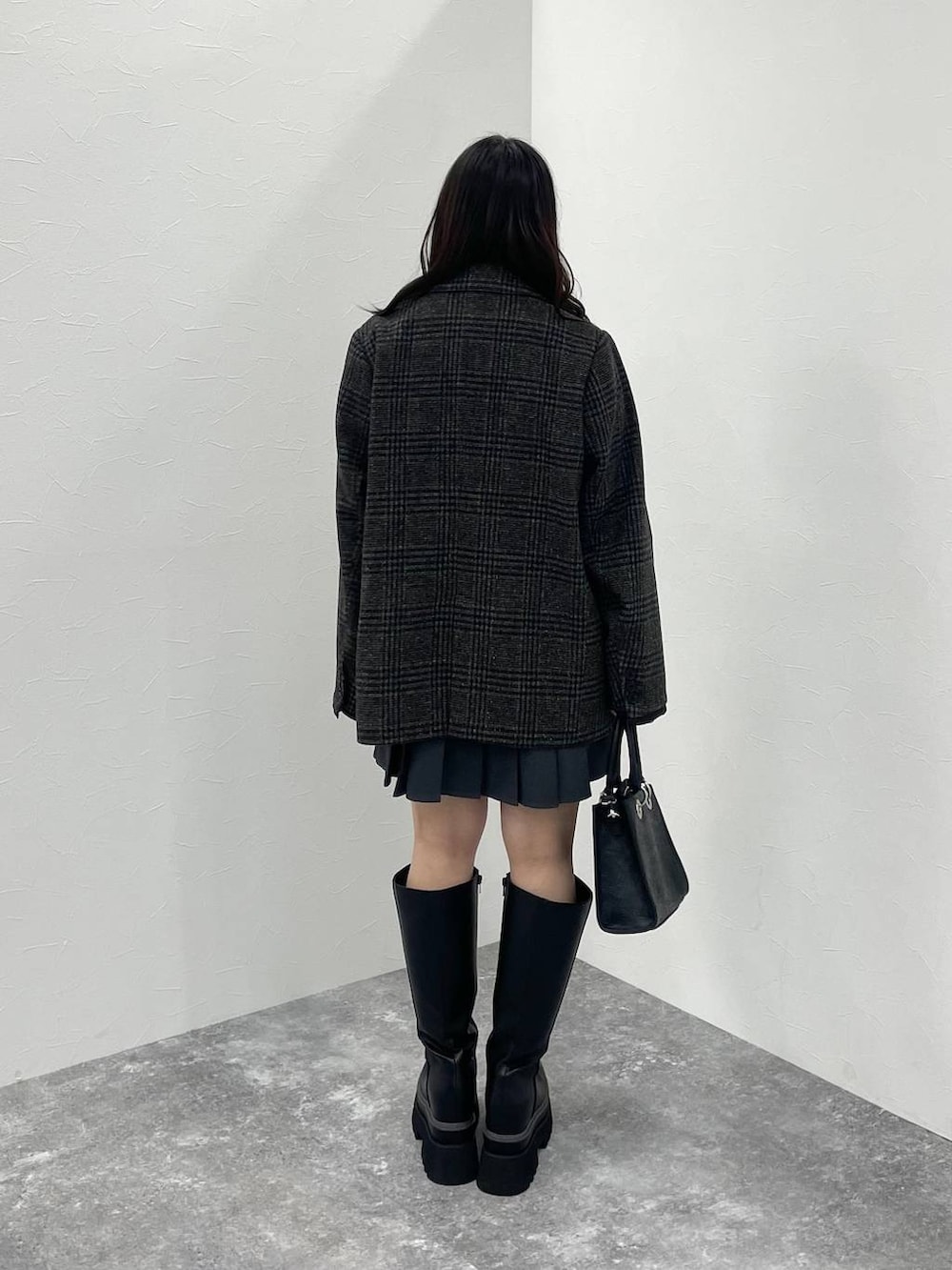 ブラック系のTシャツ/カットソー、ブラック系のショルダーバッグ、ブラック系のブーツを着用したレディースの秋コーディネートの3枚目の写真