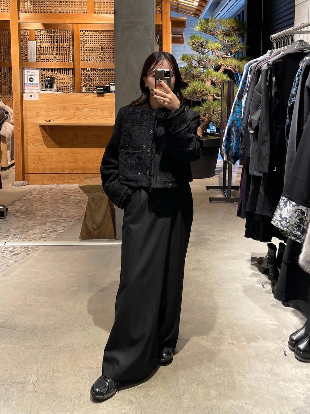 ブラック系のノーカラージャケット、ブラック系のスラックスを着用したレディースの秋コーディネートの2枚目の写真