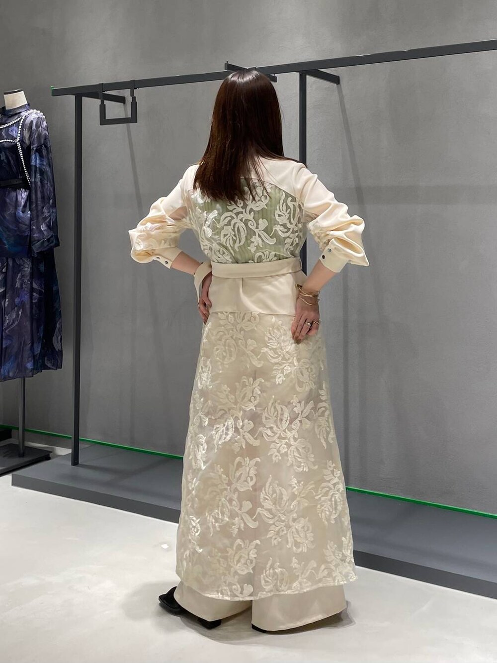 イエロー系のタンクトップ、ホワイト系のワンピース、ホワイト系のその他パンツを着用したレディースの春コーディネートの3枚目の写真