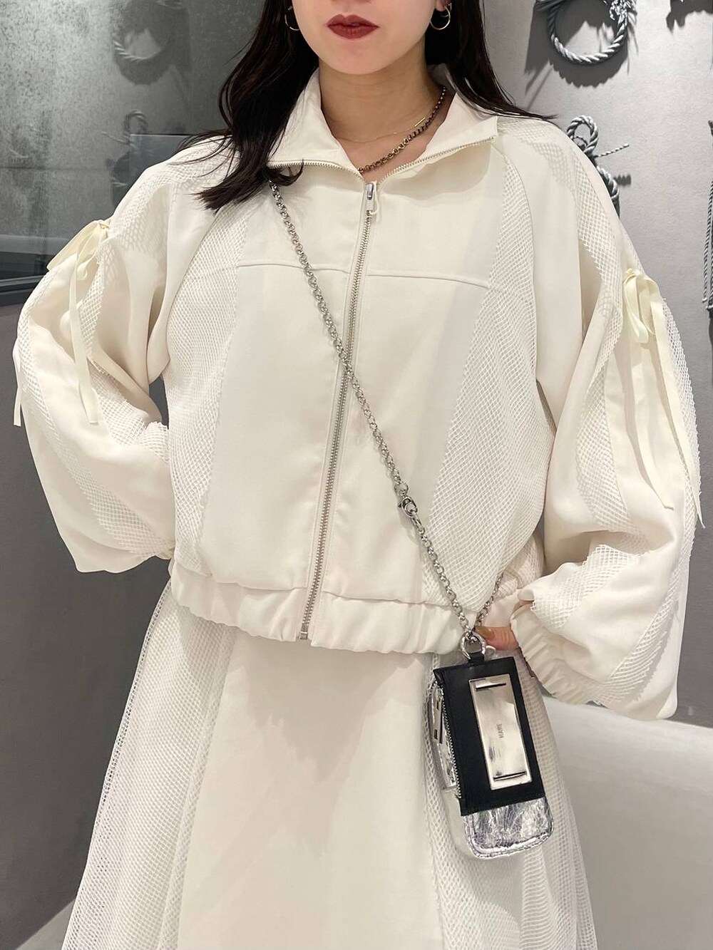 ブラック系のブーツ、ホワイト系のスカート、ホワイト系のブルゾンを着用したレディースの冬コーディネートの5枚目の写真