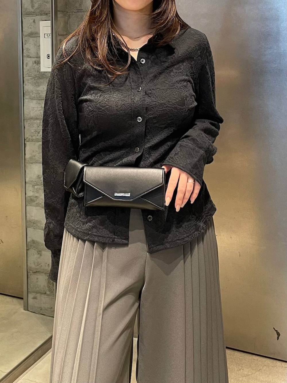 ブラック系のサンダル、ブラック系のボディバッグ/ウエストポーチ、グレー系のスラックスを着用したレディースの春コーディネートの6枚目の写真