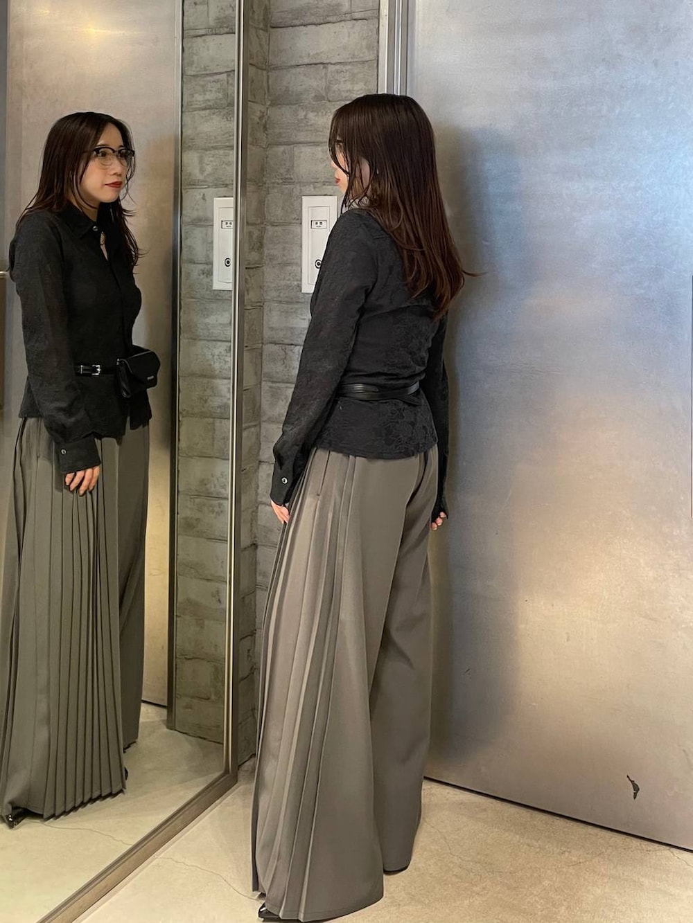 ブラック系のサンダル、ブラック系のボディバッグ/ウエストポーチ、グレー系のスラックスを着用したレディースの春コーディネートの3枚目の写真