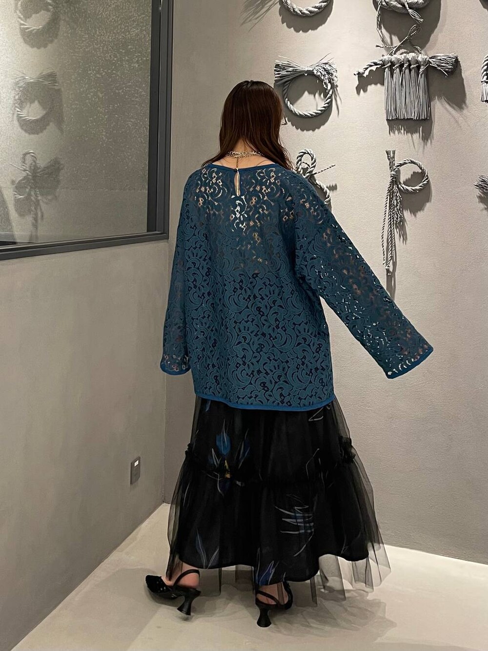 ブラック系のパンプス、ブラック系のスカート、グリーン系のTシャツ/カットソーを着用したレディースの春コーディネートの3枚目の写真