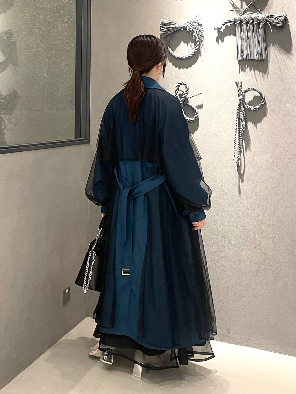 ホワイト系のサンダル、ブルー系のドレス、ブルー系のトレンチコートを着用したレディースの秋コーディネートの2枚目の写真