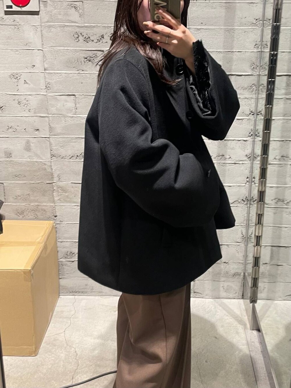 ブラック系のノーカラーコート、ブラウン系のその他パンツ、ブラック系のTシャツ/カットソーを着用したレディースの冬コーディネートの4枚目の写真