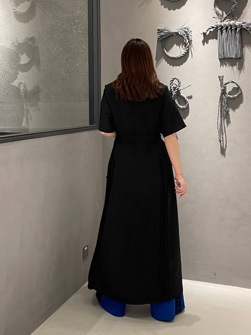 ブラック系のパンプス、ブルー系のその他パンツ、ブラック系のワンピースを着用したレディースの春コーディネートの3枚目の写真