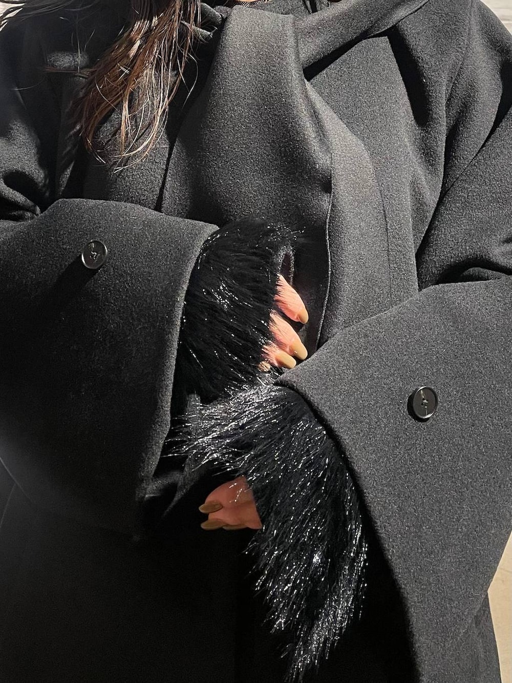 ブラック系のブーツ、ブラック系のノーカラーコート、ブラウン系のその他パンツを着用したレディースの冬コーディネートの7枚目の写真