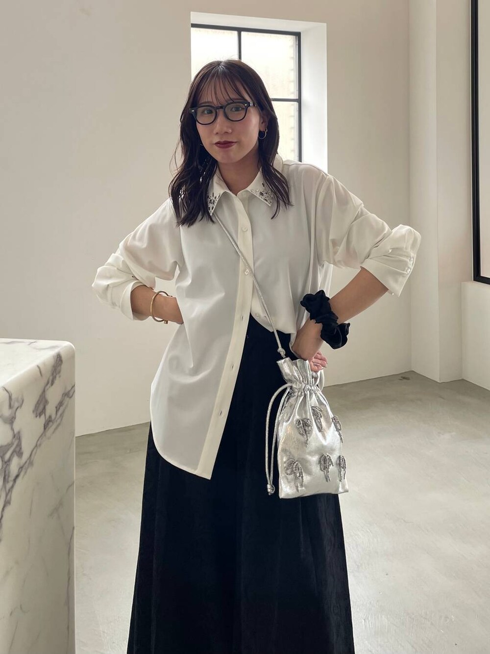 ブラック系のタンクトップ、ブラック系のブーツ、シルバー系のショルダーバッグを着用したレディースの夏コーディネートの3枚目の写真