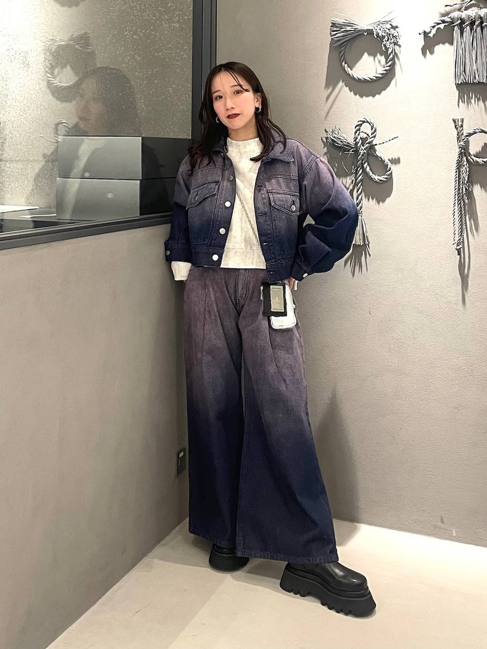 ホワイト系のスウェット、パープル系のデニムジャケット、パープル系のデニムパンツを着用したレディースの冬コーディネートの6枚目の写真