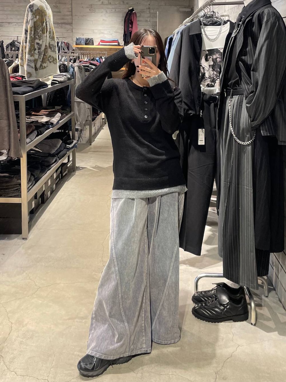 ブラック系のニット/セーター、グレー系のデニムパンツを着用したレディースの秋コーディネートの2枚目の写真