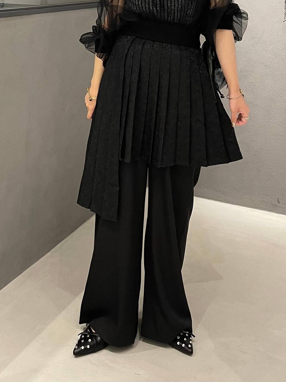 ブラック系のタンクトップ、ブラック系のショルダーバッグ、ブラック系のパンプスを着用したレディースの夏コーディネートの6枚目の写真