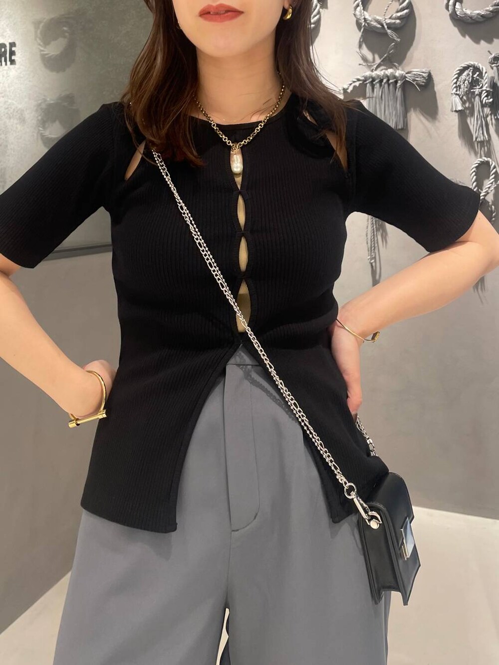 ホワイト系のサンダル、グレー系のその他パンツ、ブラック系のTシャツ/カットソーを着用したレディースの春コーディネートの3枚目の写真