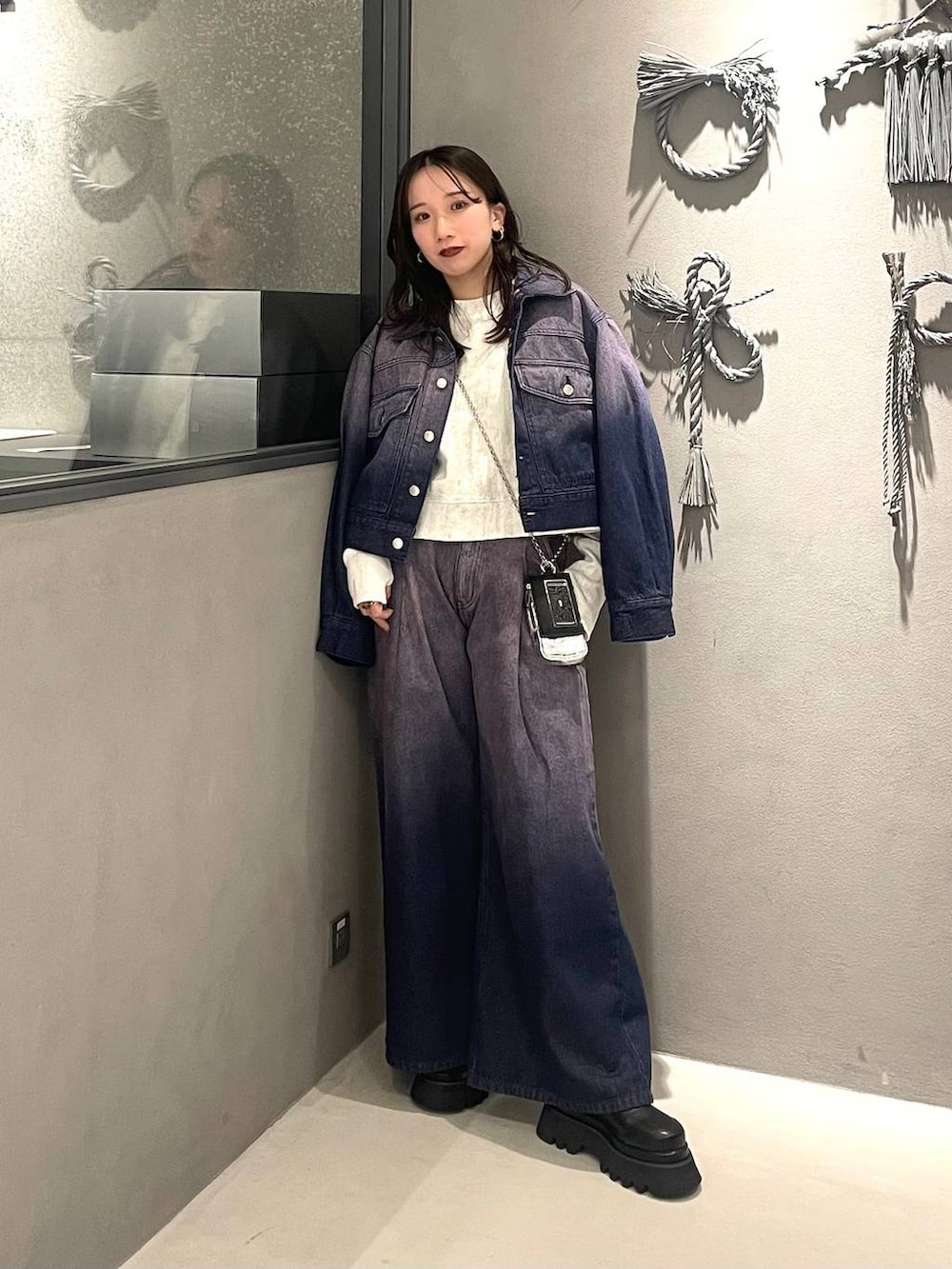 ホワイト系のスウェット、パープル系のデニムジャケット、パープル系のデニムパンツを着用したレディースの冬コーディネートの5枚目の写真