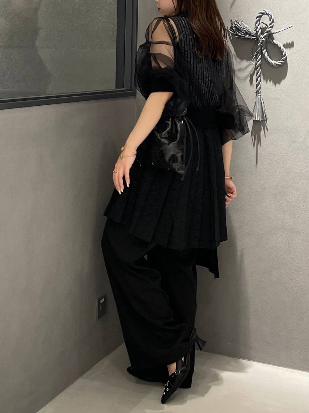 ブラック系のタンクトップ、ブラック系のショルダーバッグ、ブラック系のパンプスを着用したレディースの夏コーディネートの4枚目の写真