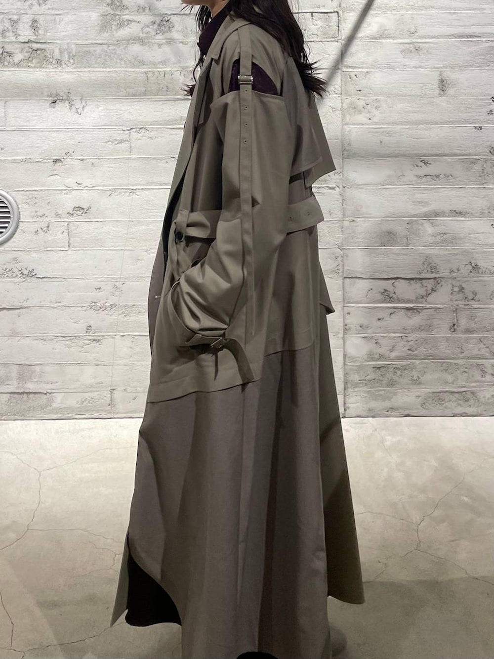 ブラック系のブーツ、レッド系のワンピース、ベージュ系のトレンチコートを着用したレディースの冬コーディネートの5枚目の写真