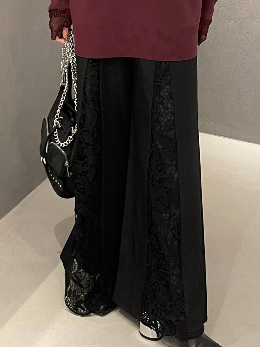 ブラック系のショルダーバッグ、ブラック系のブーツ、レッド系のTシャツ/カットソーを着用したレディースの秋コーディネートの5枚目の写真