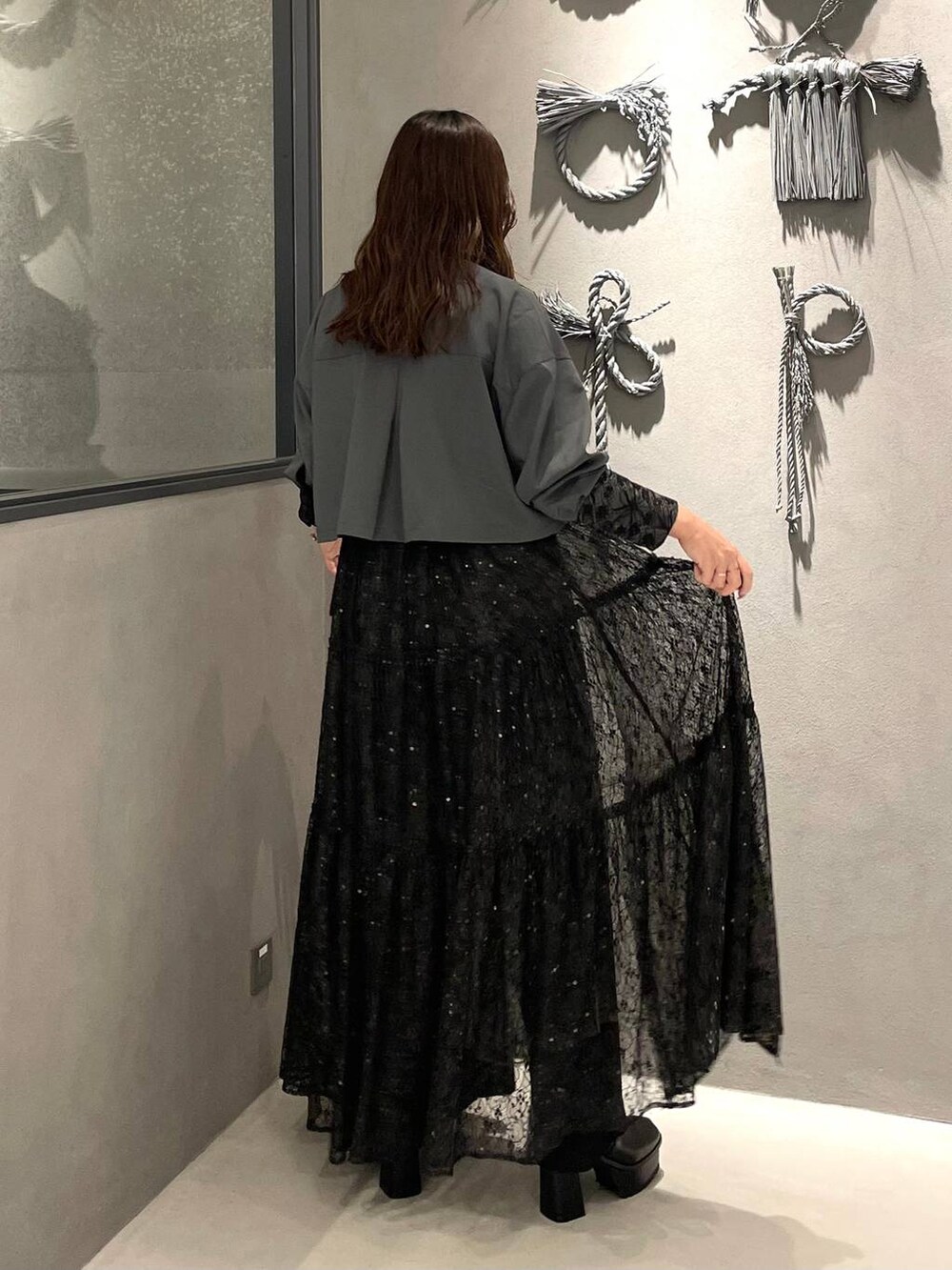 ブラック系のブーツ、グレー系のシャツ/ブラウス、ブラック系のスカートを着用したレディースの秋コーディネートの3枚目の写真