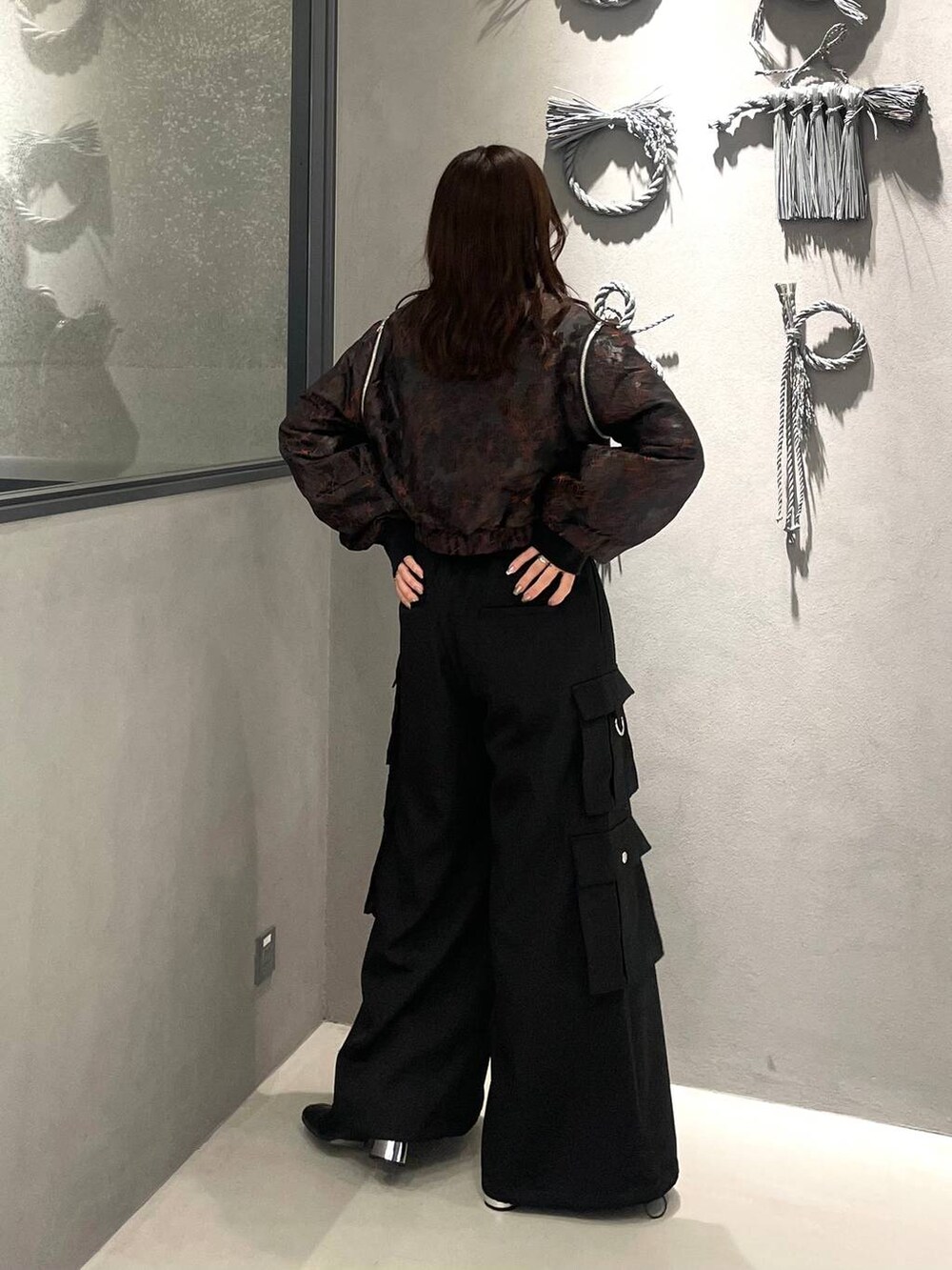 オレンジ系のブルゾン、ブラック系のブーツ、ブラック系のニット/セーターを着用したレディースの秋コーディネートの3枚目の写真