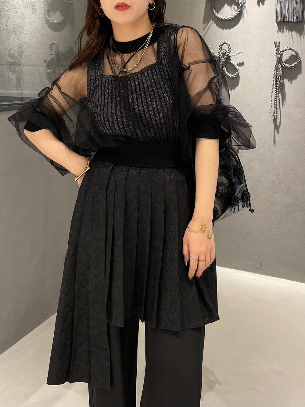 ブラック系のタンクトップ、ブラック系のショルダーバッグ、ブラック系のパンプスを着用したレディースの夏コーディネートの5枚目の写真