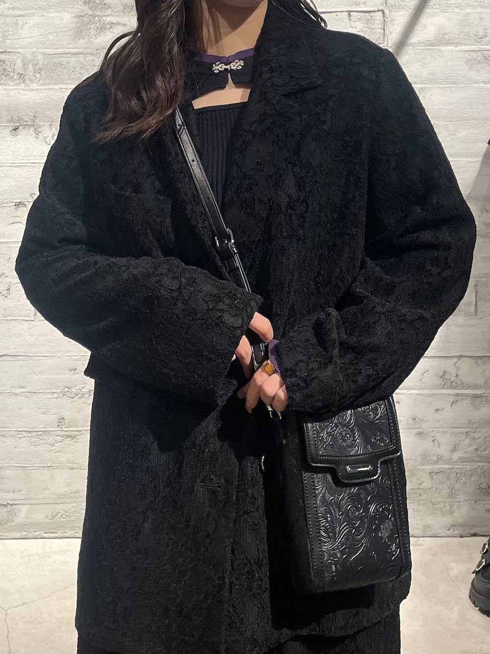 ブラック系のニット/セーター、ブラック系のブーツ、ブラック系のショルダーバッグを着用したレディースの秋コーディネートの5枚目の写真