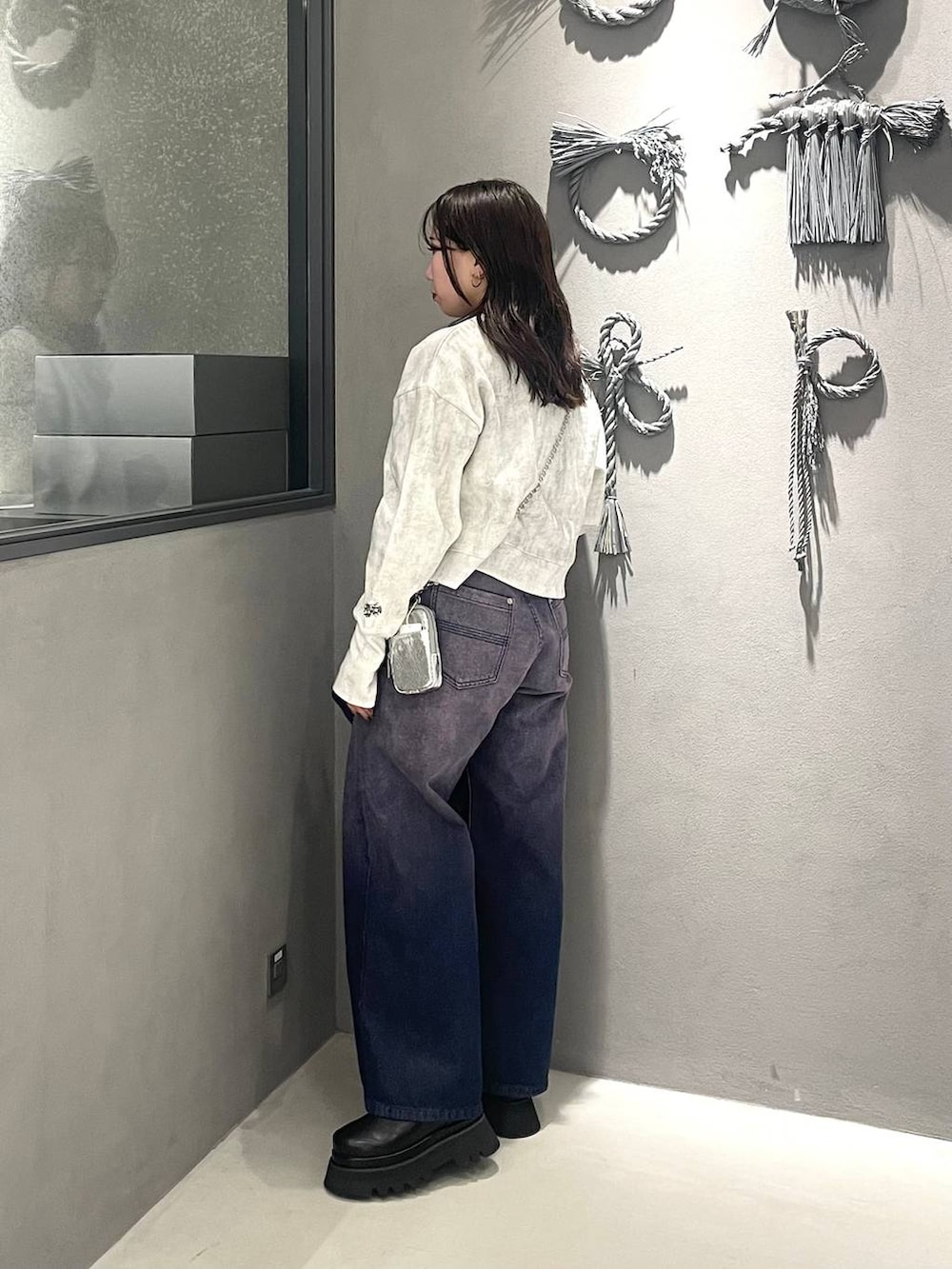 ホワイト系のスウェット、パープル系のデニムジャケット、パープル系のデニムパンツを着用したレディースの冬コーディネートの2枚目の写真