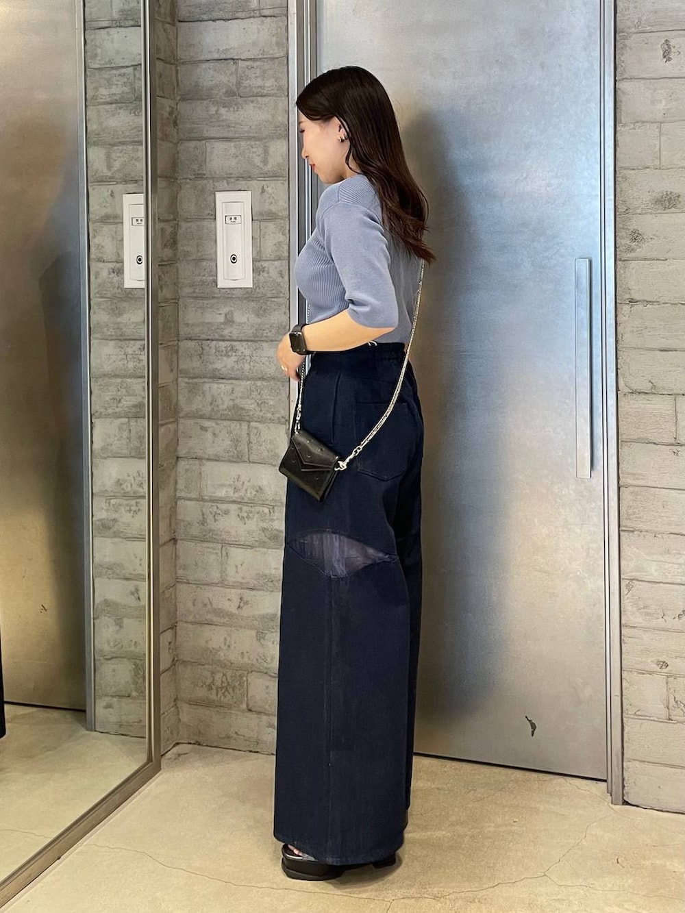 シルバー系のブーツ、ブルー系のデニムパンツ、ブルー系のニット/セーターを着用したレディースの春コーディネートの2枚目の写真