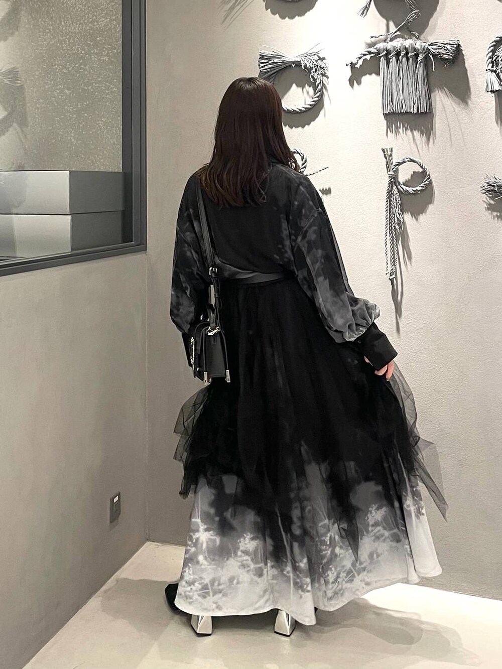 ブラック系のブーツ、ブラック系のショルダーバッグ、ブラック系のスカートを着用したレディースの冬コーディネートの3枚目の写真