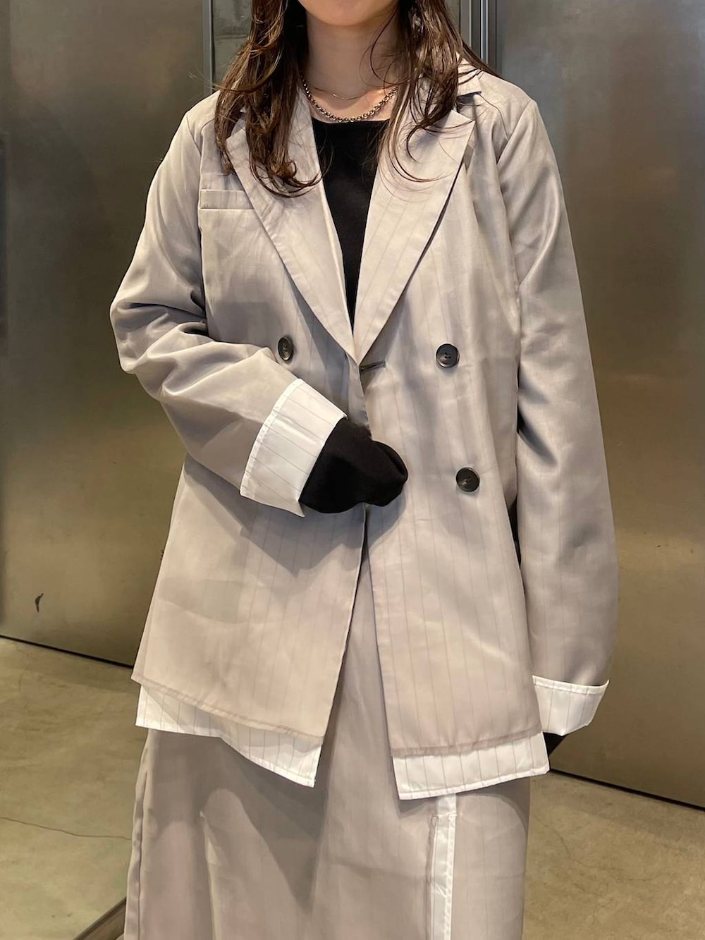 ブラック系のサンダル、ベージュ系のスカート、ベージュ系のテーラードジャケットを着用したレディースの春コーディネートの4枚目の写真