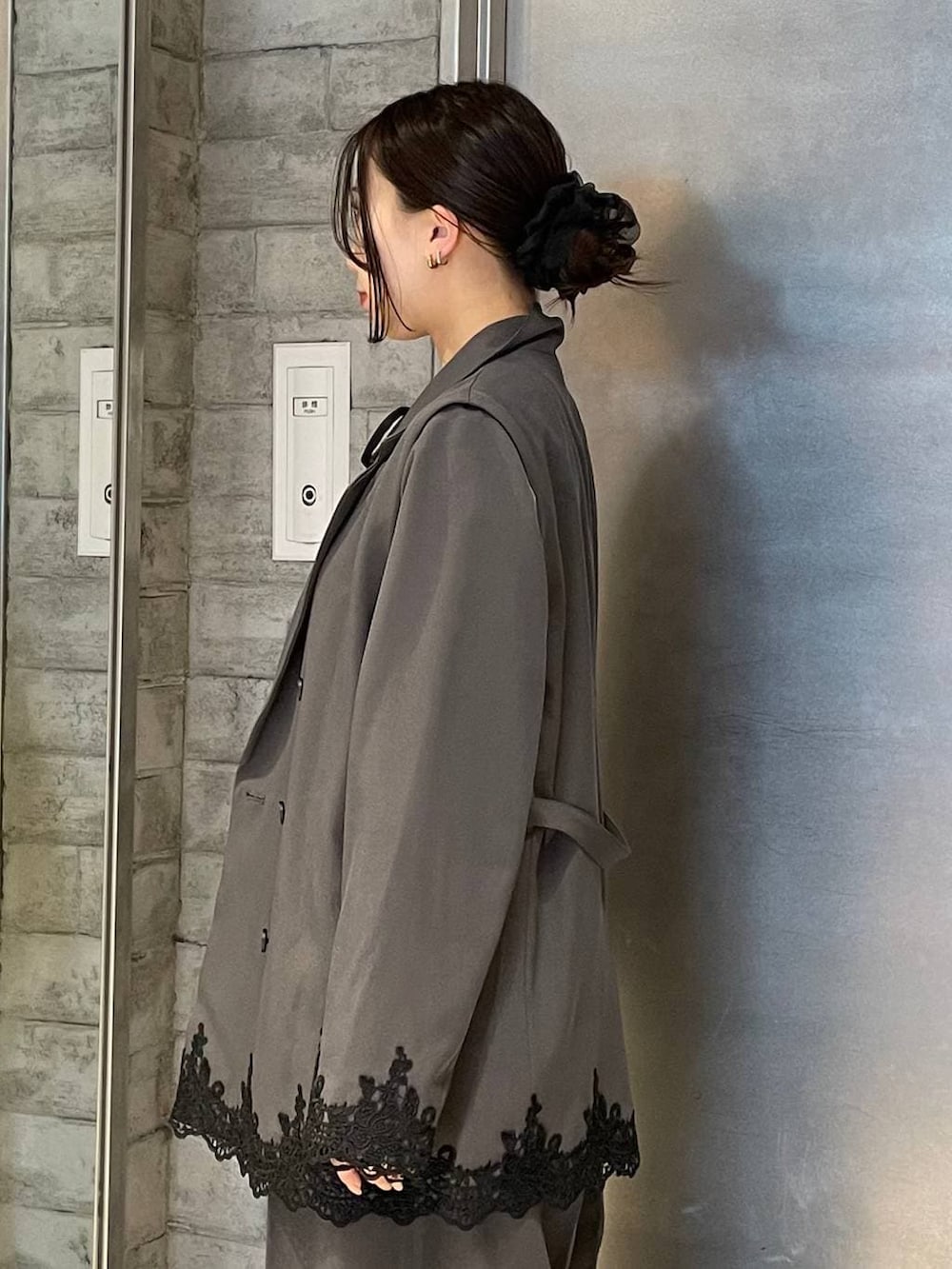 ブラック系のパンプス、グレー系のスラックス、ブラック系のTシャツ/カットソーを着用したレディースの冬コーディネートの3枚目の写真