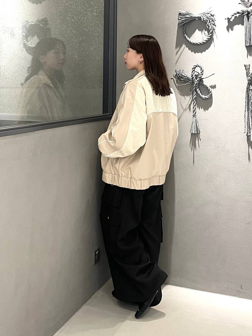 グレー系のニット/セーター、ブラック系のバレエシューズ、ブラック系のカーゴパンツを着用したレディースの秋コーディネートの2枚目の写真