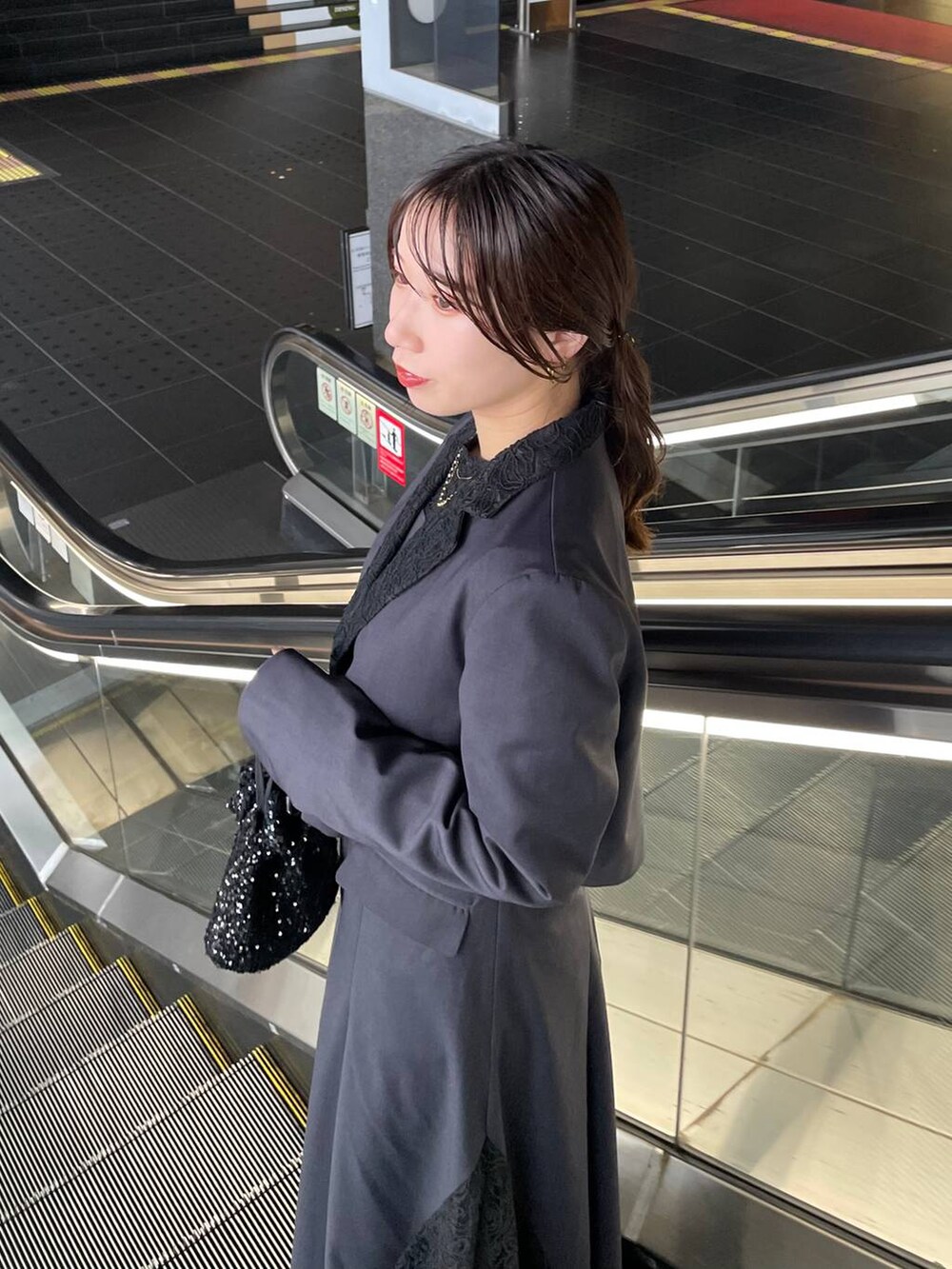 ブラック系のブーツ、グレー系のドレスを着用したレディースの秋コーディネートの4枚目の写真