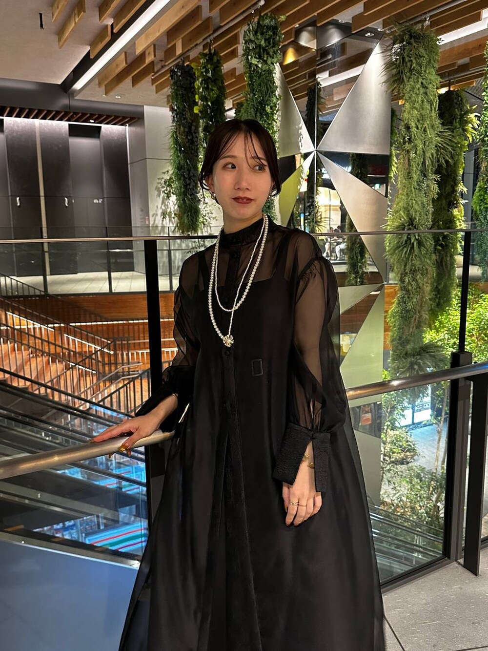 ブラック系のブーツ、ブラック系のドレス、ゴールド系のネックレスを着用したレディースの夏コーディネートの4枚目の写真