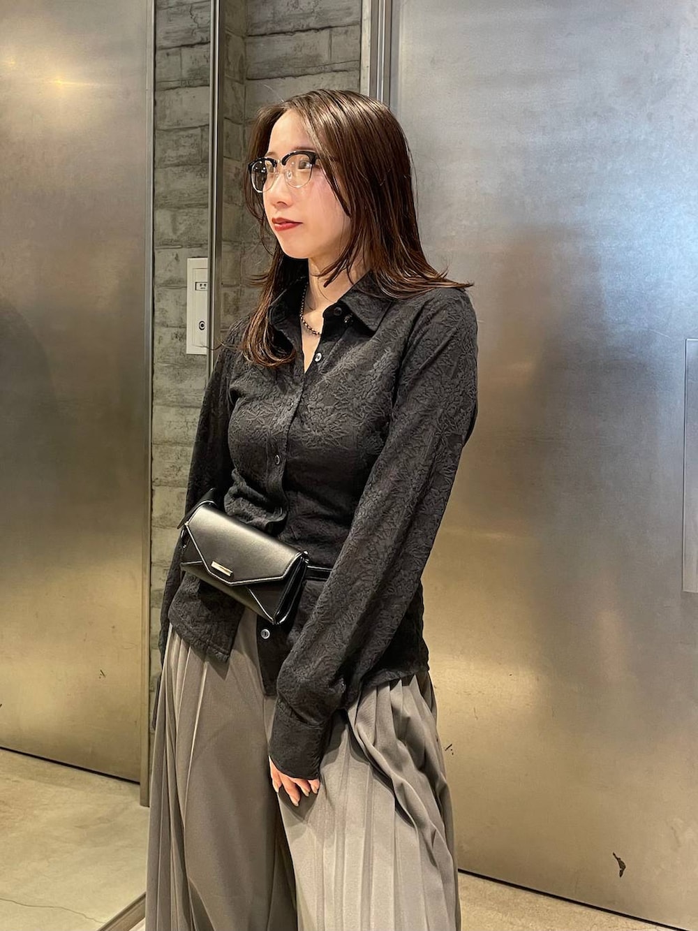 ブラック系のサンダル、ブラック系のボディバッグ/ウエストポーチ、グレー系のスラックスを着用したレディースの春コーディネートの5枚目の写真