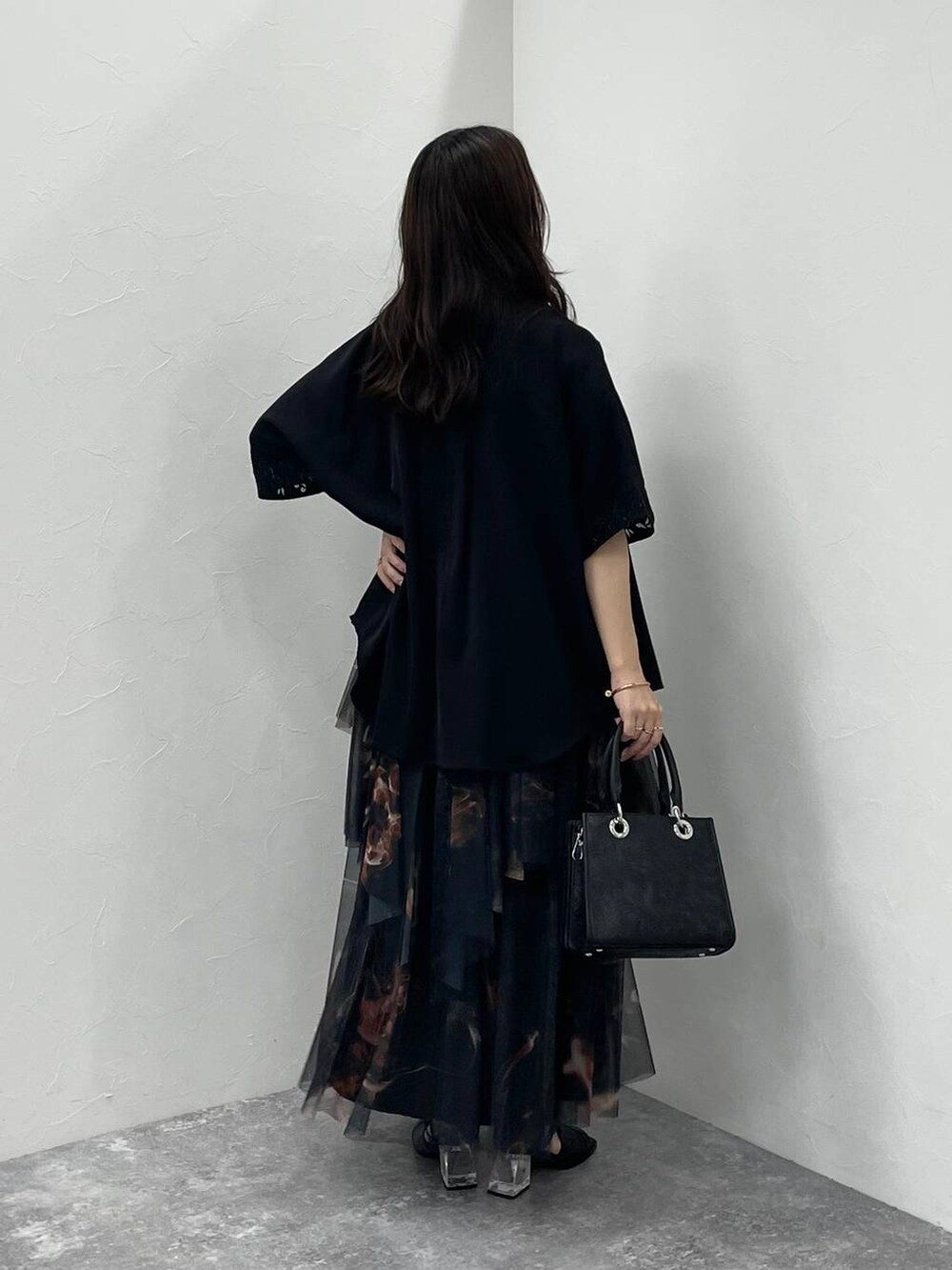 ブラック系のサンダル、ブラック系のショルダーバッグ、オレンジ系のスカートを着用したレディースの夏コーディネートの3枚目の写真