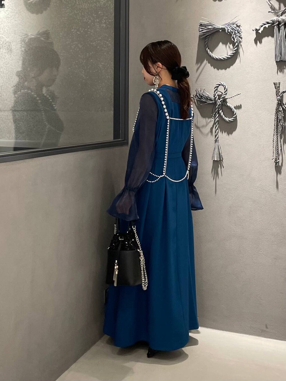 ブラック系のパンプス、ブラック系のショルダーバッグ、ホワイト系のサスペンダーを着用したレディースの秋コーディネートの3枚目の写真